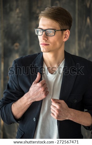 Waist up. Portrait of smilling young handsome man in glasses.