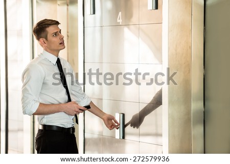 Young handsome businessman waiting on elevator of an business center.