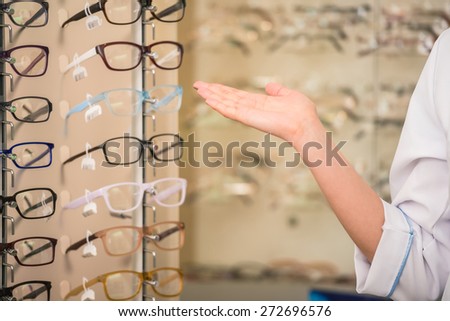 Young woman (only hands) at optician with glasses is looking for glasses.