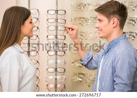 Optical store, client man and professional specialist help to choose.
