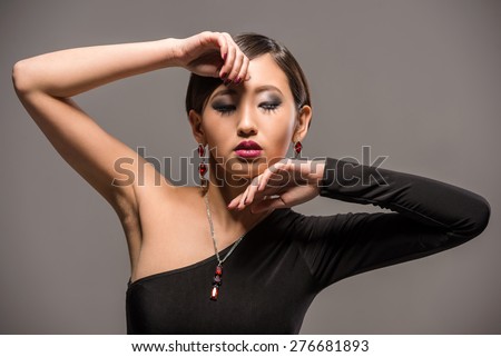 Fashion portrait of an elegant young fashion asian woman in black evening dress.