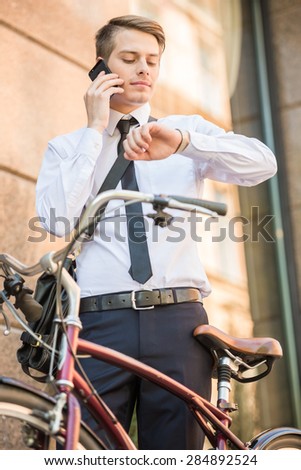 Young handsome office worker going to work on his bicycle. Healthy lifestyle concept.