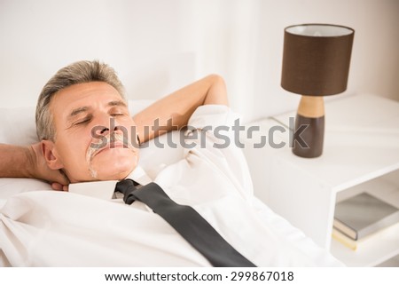Top view of businessman sleeping on bed at hotel room.