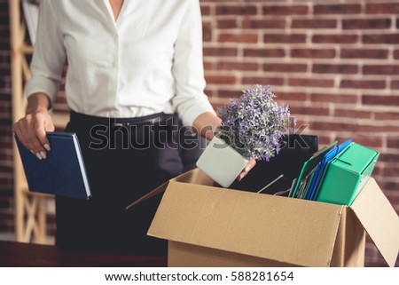 Getting fired. Cropped image of beautiful young business woman in formal wear packing her stuff into the box ストックフォト © 