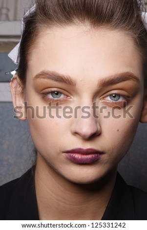 PARIS, FRANCE - MARCH 06: A model gets ready backstage at the Kenzo fashion show during Paris Fashion Week on March 6, 2011 in Paris, France.