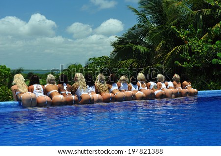 CANCUN, MEXICO - MAY 05: Models poses by the edge of pool for white t-shirt project during IBMS - International Bikini Model Search 2014 at the Oasis Sens Resort  on May 05, 2014 in Cancun, Mexico.