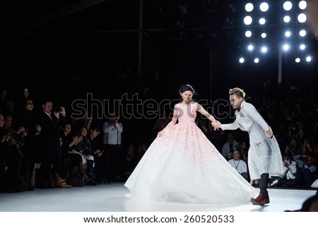 NEW YORK, NY - FEBRUARY 19: Designer Ly Qui Khanh and model walks runway at the New York Life show during MBFW Fall 2015 at Lincoln Center on February 19, 2015 in NYC.