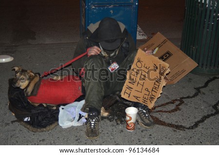 NEW YORK - FEBRUARY 25: A homeless man sitting on the street with a dog and asking for help February 25, 2012 in New York City.