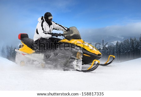 Man on snowmobile in winter mountain
