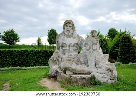 Big statue Neptune from stone in spring garden