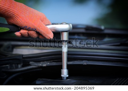 Hands of car mechanic in auto repair service