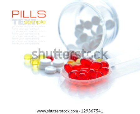 Red capsules are in a spoon on a background the color capsules