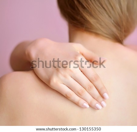 Woman with hand on shoulder. Focus is on a hand