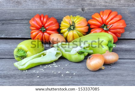 Fresh sweet green peppers with onion and tomatoes (sort Beauty Lottringa) on an old wooden table