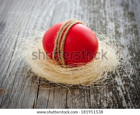 Easter red egg is in a nest on a old wooden background