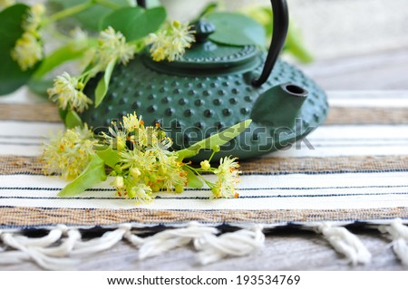 Teapot with linden tea and flowers