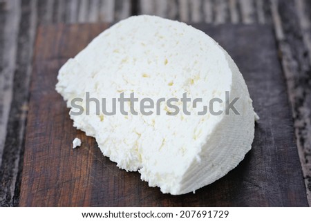 A piece of cheese on a wooden board