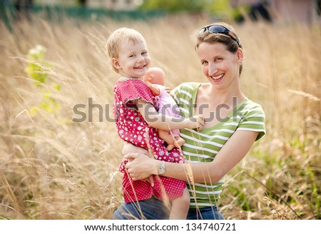 Mother is playing with her daughter outside