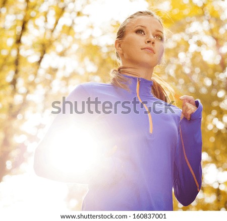 Bautiful running woman jogging in autumn nature