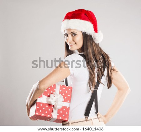 Beautiful woman with christmas hat is holding gifts, isolated on white background
