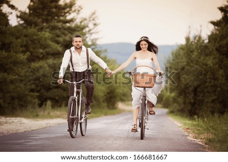 Beautiful bride and groom riding on the bikes