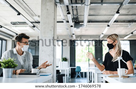 Young people with face masks back at work in office after lockdown. Foto stock © 