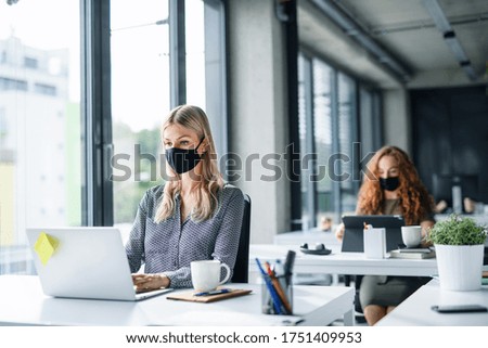 Young people with face masks back at work or school in office after lockdown. Foto stock © 