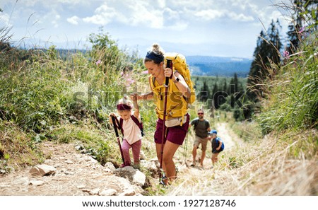 Family with small children hiking outdoors in summer nature, walking in High Tatras.