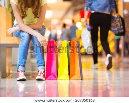 Shopping time, closeup of teenage girl\'s legs with shopping bags at shopping mall