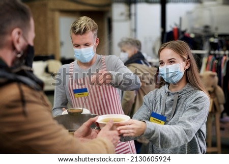 Volunteers serving hot soup for Ukrainian migrants in refugee centre, Russian conflict concept. Сток-фото © 