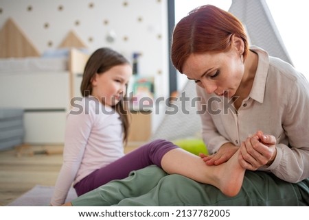 Mother blowing her little daughter's hurt ankle. Stock foto © 