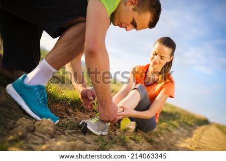 Injury - sports woman with twisted sprained getting help from man touching her ankle.