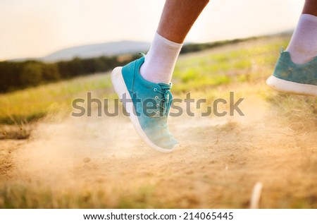 Runner man feet running on countryside road, closeup on shoe