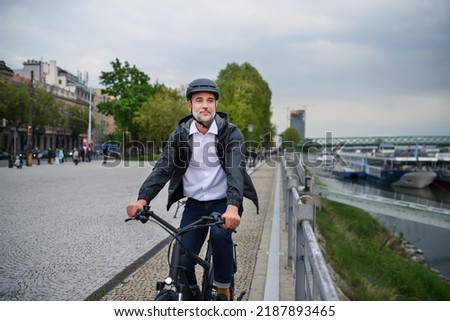 Similar – Image, Stock Photo Man riding bike next to buildings