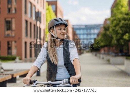 Image, Stock Photo Middle aged woman riding his electric scooter and looking at mobile phone.