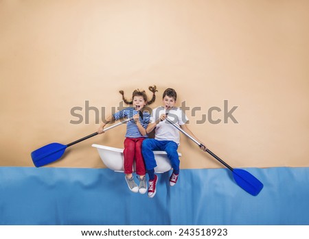 Joyful kids as sailors on the sea. Studio shot on a beige background.