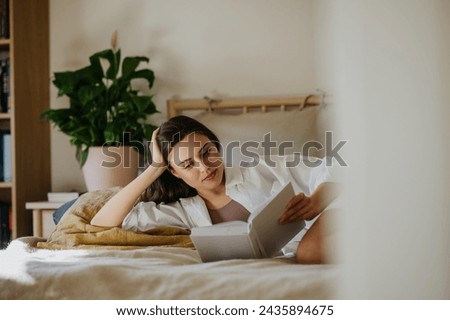 Similar – Image, Stock Photo Woman reading a book in cafe sitting at wooden table with flowers in a vase. Romantic date with a book. Brown vintage neutral color background. Literature & Library, book lover spending leisure time.