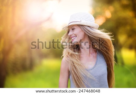 Attractive young woman enjoying her time outside in park with sunset in background.