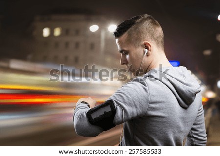 Young sportsman jogging in the night city