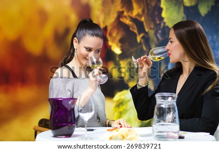 Two beautiful women having fun in a wine bar