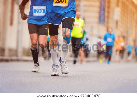 Unrecognizable young runner with injured knee at the city race