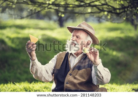 Senior farmer with organic cheese outside in green nature
