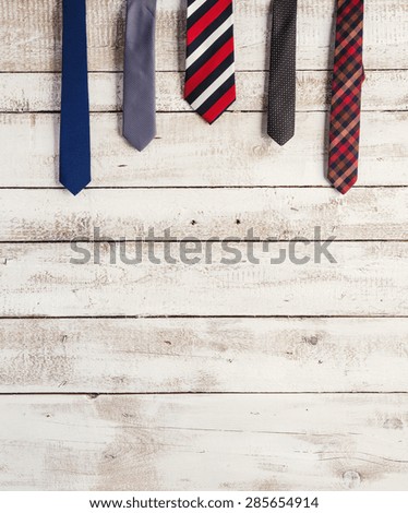 Fathers day composition of various ties hang on wooden wall background.