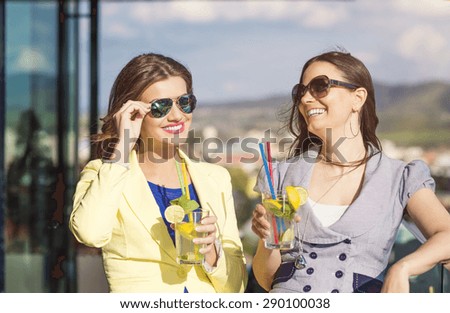 Two beautiful women having fun in a bar