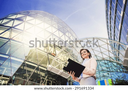 Attractive young business woman with clipboard in the city