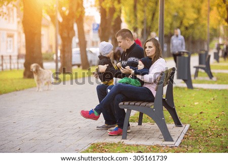 Happy young family on a walk in autumn city park