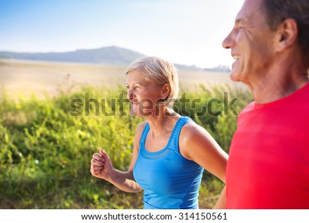 Active seniors running outside in green nature