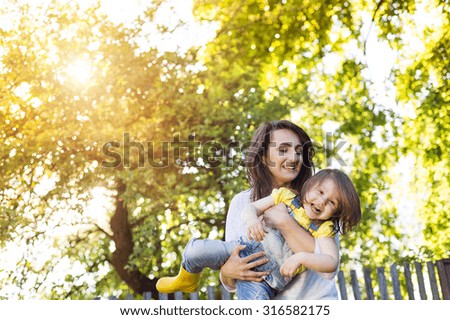 Happy mother and daughter outside in green nature