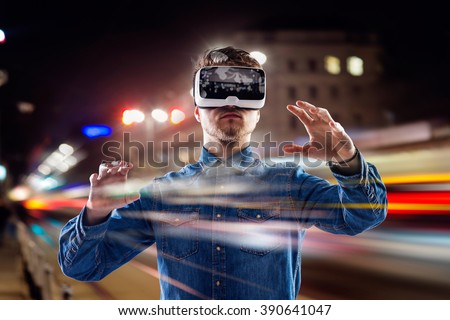 Double exposure, man wearing virtual reality goggles, night city 商業照片 © 