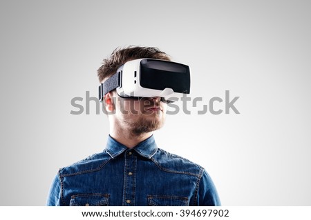 Man wearing virtual reality goggles. Studio shot, gray backgroun 商業照片 © 